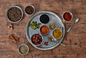 Various Thai spices: red curry, yellow curry, Kafir lime leaves, cloves, anise, cinnamon, nutmeg, cardamom, chilli powder, dried chillis