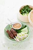 Minced meat skewers with rice, bok choy and peanut sauce (India)
