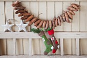 Garland of fir cones on beige board wall