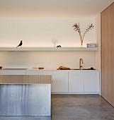 White minimalist kitchen with a few ornaments on floating shelves and floor-to-ceiling wooden sliding door