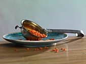 Red lentils in a ladle on a plate