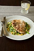 A pork chop with a bean salad and Parmesan cheese