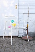 White lattice garden chair decorated with pastel balloons