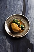 Guinea fowl breast with a peanut and lemon rust and orange spinach (Turkey)