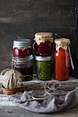 Homemade jams and sources against a rustic wooden wall