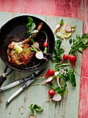Caramelised pork chop with herb butter and radishes (seen from above)