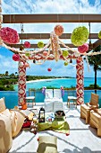 Indisches Hochzeitsfest - Stühle mit weissen und goldenen Hussen, unter Pergola mit Blumenverzierung am Meer