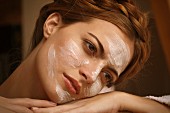 A brunette woman relaxing with a face mask