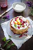 A pancake tower with ricotta and pomegranate seeds