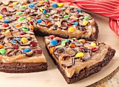Brownie pizza topped with peanut butter and colourful chocolate beans