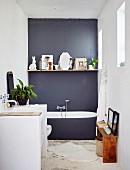 Minimalistisches Bad mit dunkelgrauer Wand und Regalbrett, davor gemauerter Waschtisch