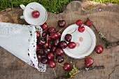 Crockery printed with cherry pattern and paper cone of cherries