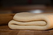 Folded yeast dough on a wooden surface
