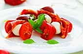 Tomatoes with mozzarella, salami and basil
