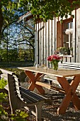 Rustikaler Sitzplatz in der Herbstsonne vor Holzhaus