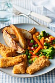 Crispy fish fingers with vegetables and potato wedges
