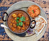 Panner curry with naan bread and a carrot and sesame seed salad (India)