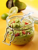 Guacamole in a preserving jar with a spoon