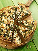 Spelt wholemeal quiche with spinach and pine nuts, sliced