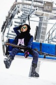 Junge Frau in Ski-Ausrüstung sitz in Sessellift