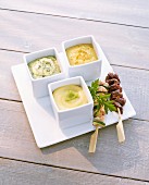 Herb mayonnaise, wasabi mayonnaise and curry mayonnaise as a dip for skewers