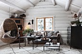 Hanging chair in cosy living room in log cabin