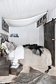 Gemütliches Schlafzimmer mit Betthimmel und Fell