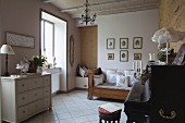 Vintage-style scatter cushions on antique couch, pale chest of drawers and piano in music room