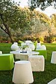 Designer Outdoor-Sitzmöbel in Grün und Weiß um runde Tische im Garten