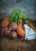 An arrangement of vegetables, cheese, herbs and peppercorns