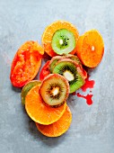 Kiwi slices, halved oranges and juiced blood oranges (seen from above)