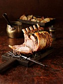 Carved rack of pork on a chopping board