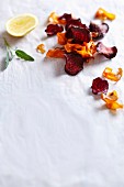 Deep-fried carrots and beetroot chips on a white surface
