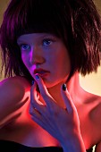 A young woman with a pageboy haircut and black, glittery nail varnish