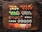 Various types of sushi on a rustic wooden platter