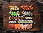 Viele verschiedene Sushis auf rustikaler Holzplatte