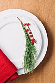 A pin sprig and a sprig of berries as plate decoration (seen from above)