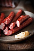 Thin grilled sausages with mustard