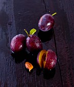Freshly washed damsons on a wooden surface