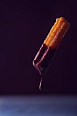 A churro dripping with chocolate