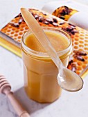 A jar of honey with a spoon