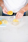 Citrus fruit slices being dipped into sugared water