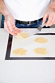 Baked Parmesan chips being removed from a baking tray with a palette knife