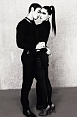 A young couple dressed in black embracing (black-and-white shot)