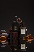 Drei dunkle Parfumflakons vor schwarzem Hintergrund (Winterdüfte)