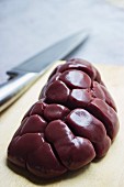 Raw kidneys are chopping board with a kitchen knife