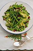 A plate of green vegetables with pomegranate seeds fro Christmas