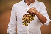 A man holding grapes