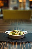 Kartoffelsalat mit Pfefferbeeren & Kapern in Schale auf Restauranttisch