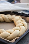 An unbaked bread wreath on a baking tray